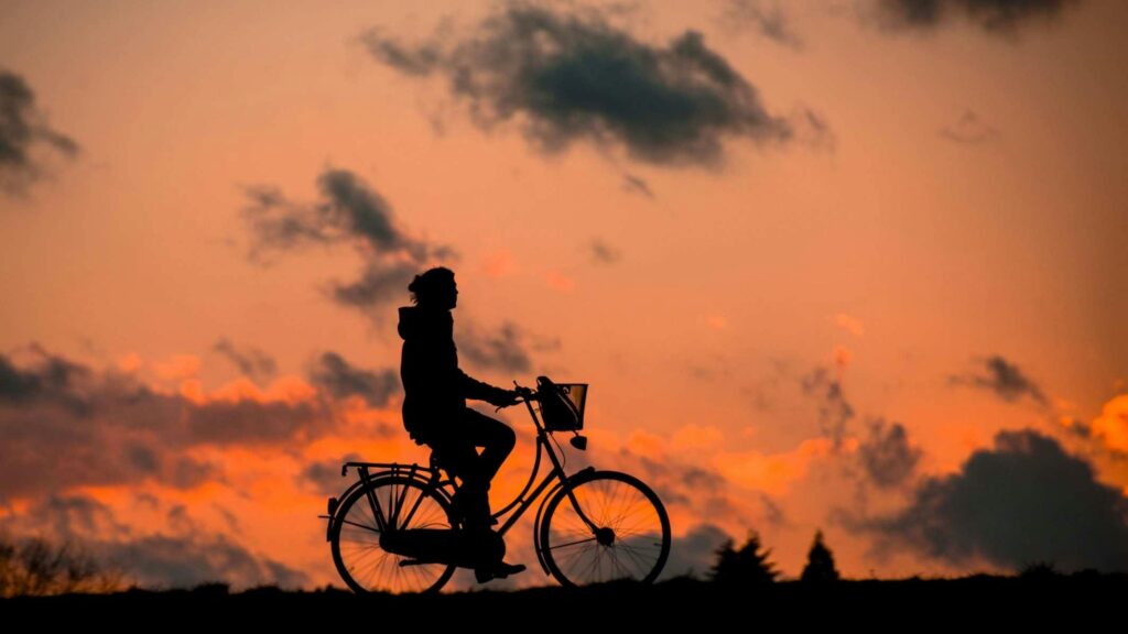 Cyclist at sunset with orange sky